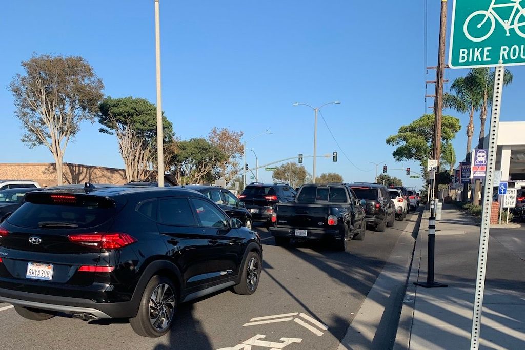 a line of cars squeezing a tiny road sharrow